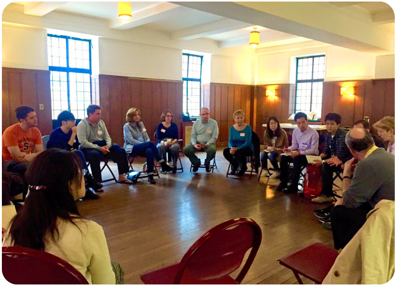 A photo from the early 2000s of a PFLAG NYC support group meeting depicting a group of people sitting in folding chairs in a circle