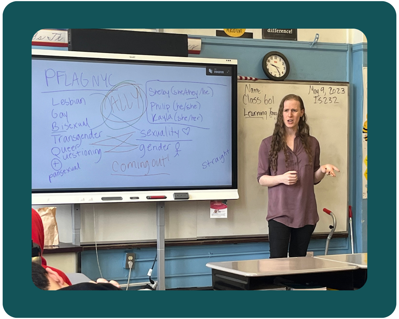 A teal-framed photo of a PFLAG NYC Safe Schools volunteer speaking at the front of a classroom