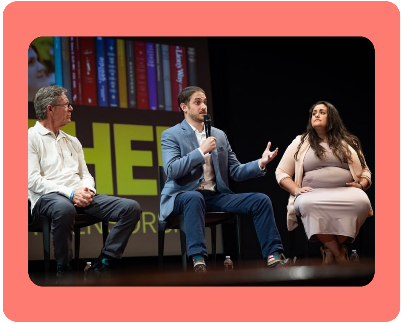 A photo of PFLAG NYC executive director Melissa sitting in a chair on a stage next to two men for a panel discussion about the film, Banned Together