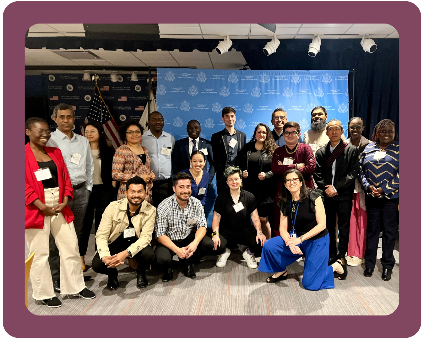 A photo of the PFLAG NYC Executive Director, Melissa D'Andrea Sullivan, surrounded by diverse delegates from 22 countries for a U.S. State Department event.