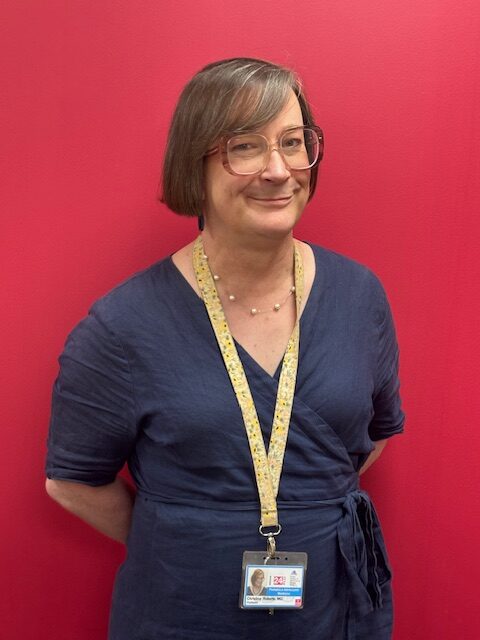 A headshot of Dr. Roberts in front of a red background